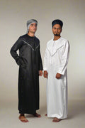 Two individuals wearing black and white traditional outfits on a white background