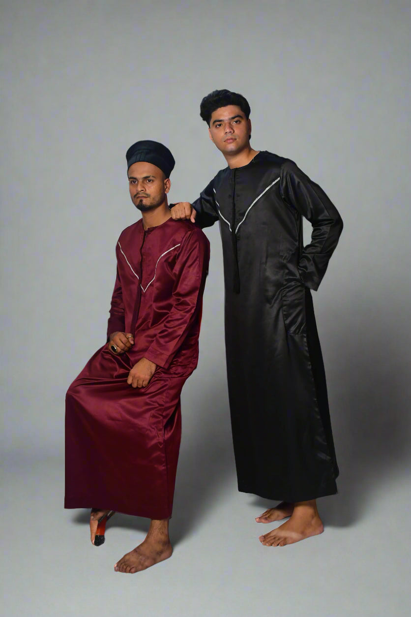 Two individuals in traditional attire standing on a white platform with a red border.