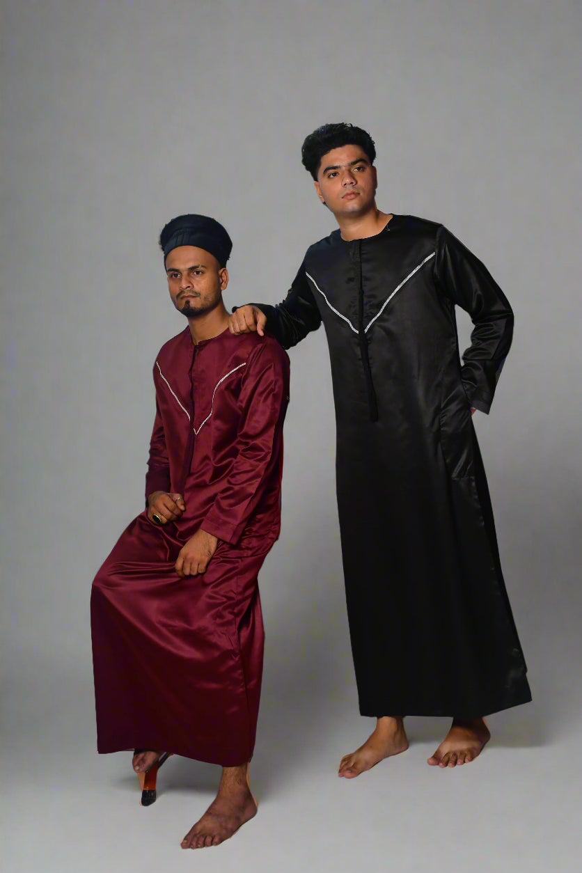 Two individuals wearing maroon and black outfits on a white background