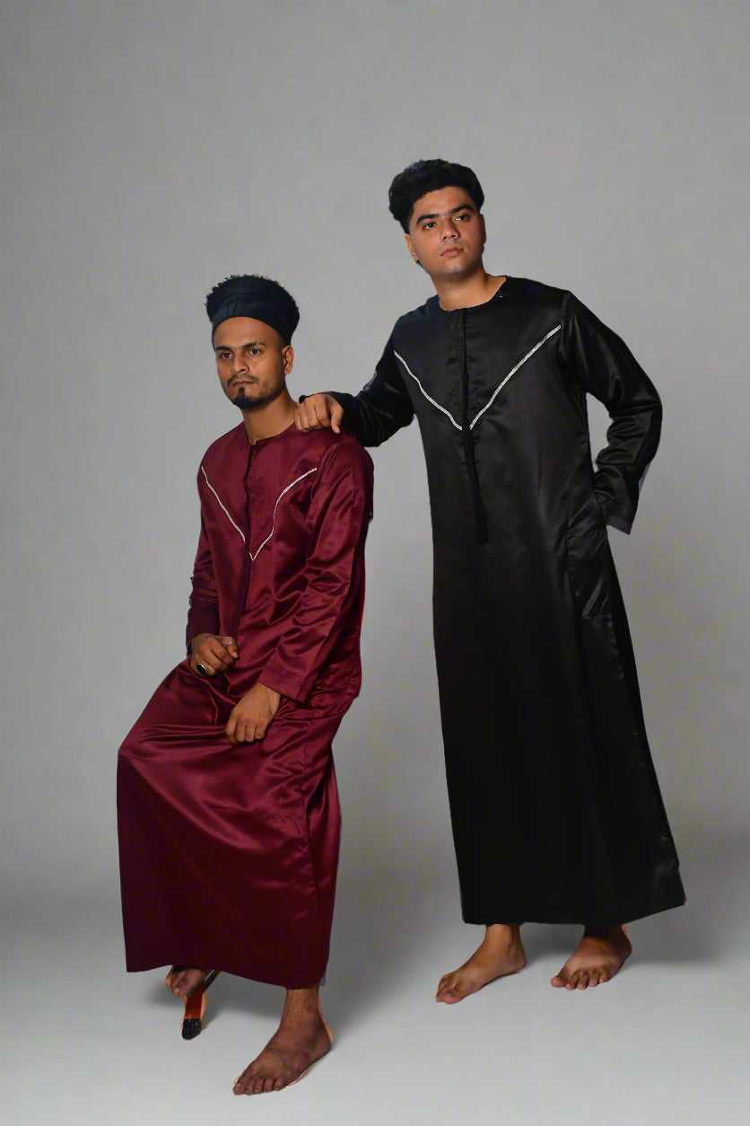 Two individuals wearing maroon and black outfits standing on a white background.