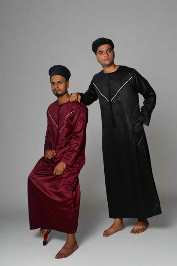 Two individuals wearing maroon and black outfits standing on a white background.