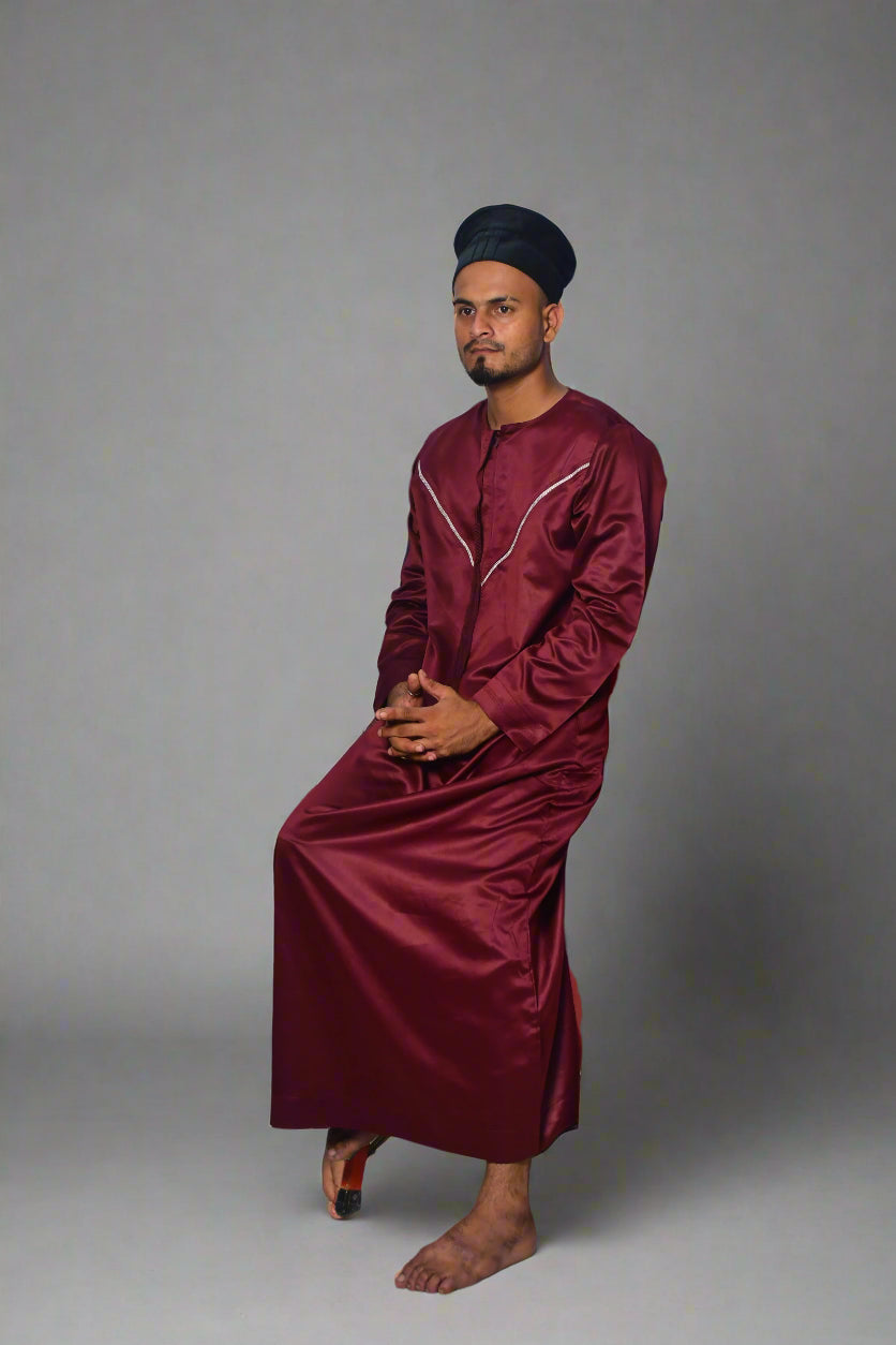 Person in maroon outfit using orange crutches on a white background