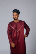 Man wearing a maroon traditional outfit with a white background
